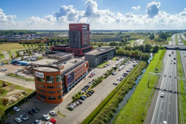 Luchtfoto van de Laan van Barcelona in Almere met kantoorgebouwen, een hotel, parkeerplaatsen en de snelweg A6.